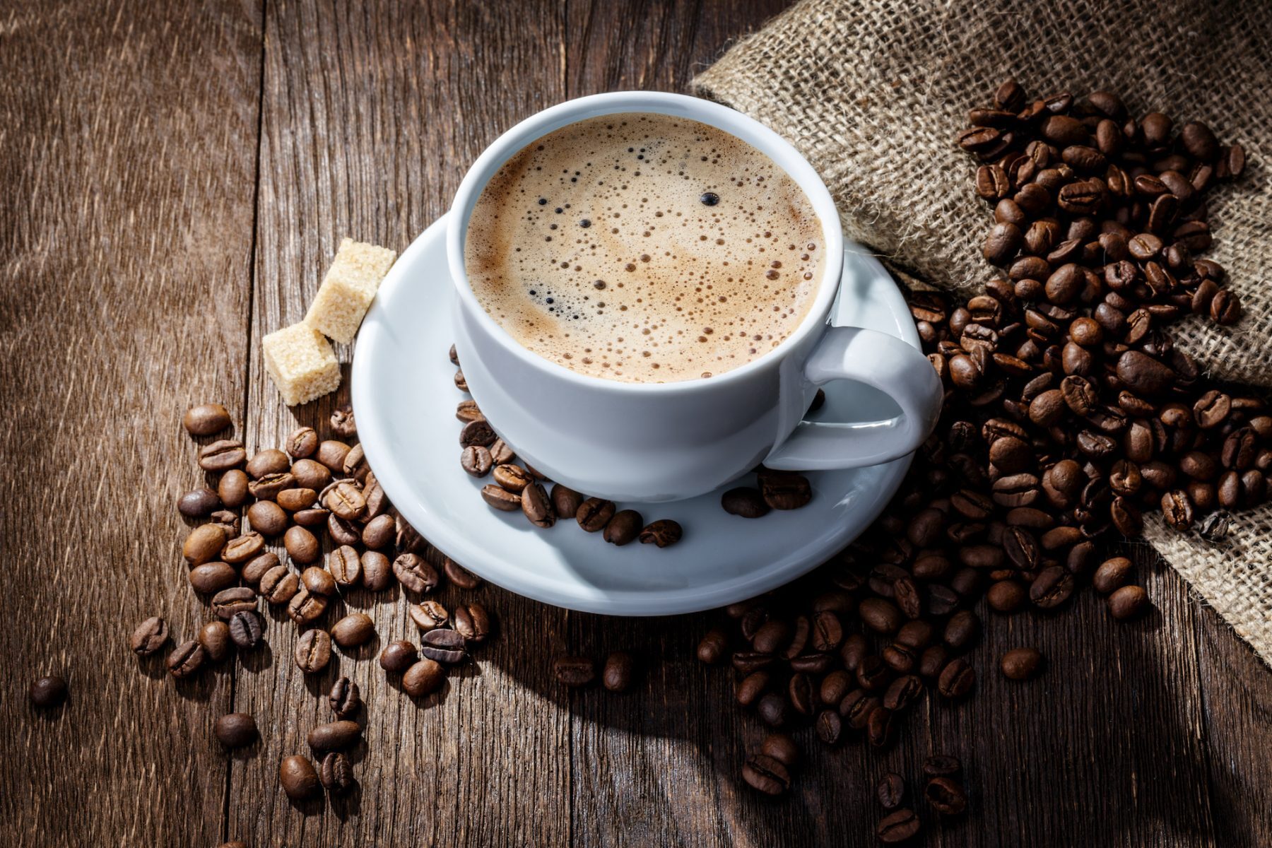 white mug of coffee beans on a wooden background Nashville office coffee