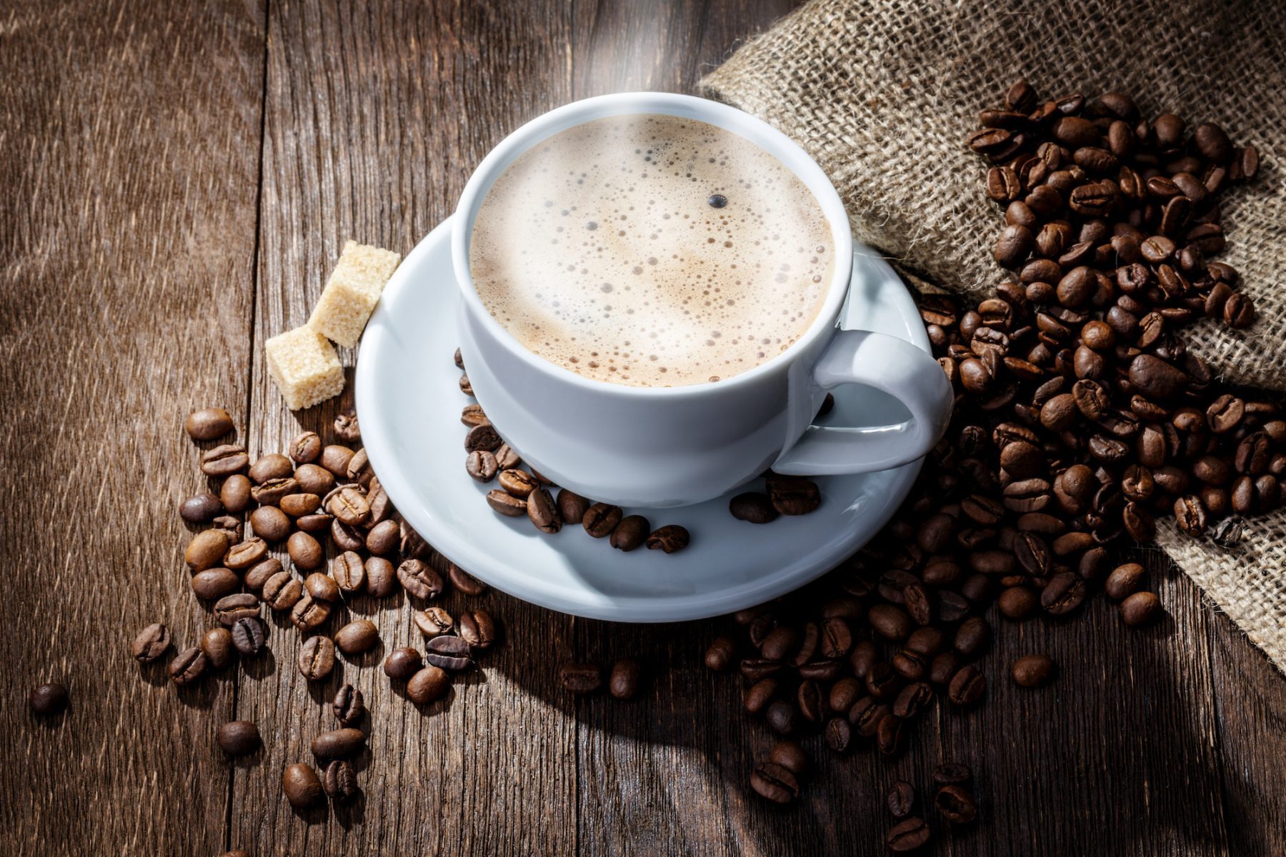 white mug of coffee beans on a wooden background Seattle office coffee service