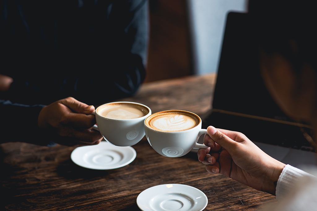 Close-up of a man and woman clinking a white coffee cup in a cof office coffee and beverage vending machines in Tampa