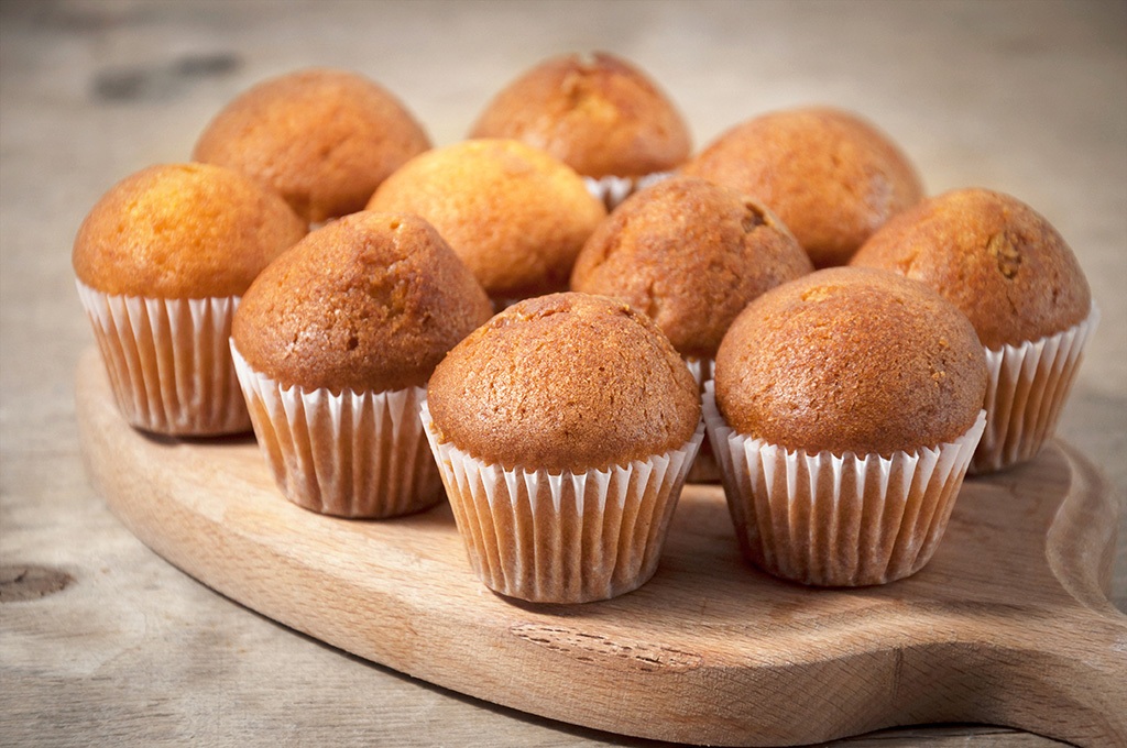 Small chocolate muffins on a wooden cutting board. Sweet dessert Durham office pantry service and healthy vending service